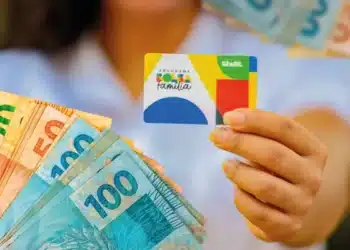Cartão do Bolsa Família com notas de reais de diferentes valores, representando o programa de assistência social do Brasil.