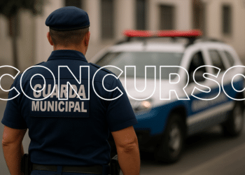 Guarda municipal de costas com uniforme azul e viatura ao fundo representando concurso público para a corporação.