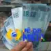 Estudante segurando notas de 100 reais representando o início da primeira etapa do Pé-de-Meia para receber R$ 1.050