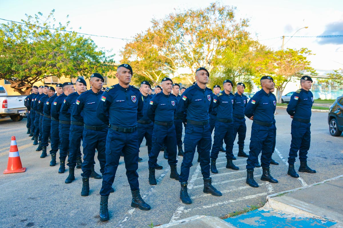 Guardas Municipais uniformizados em formação na rua, usando boinas e botas pretas, com árvores ao fundo.