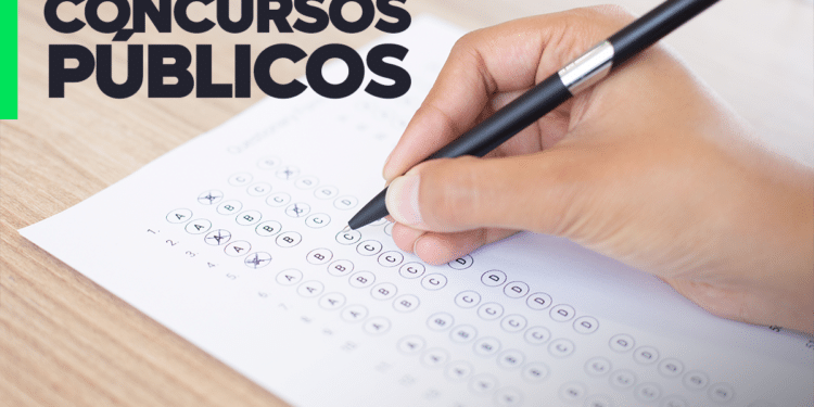 Mão preenchendo gabarito de prova sobre concursos TJ 2026