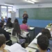 Professor ensina alunos em sala de aula com lousa e carteiras organizadas, educação escolar em 2026