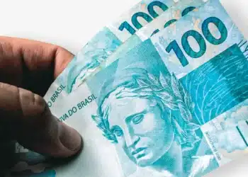 Imagem de cédulas de 100 reais do Brasil, ilustrando o tema do reajuste de benefícios em 2026.