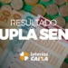 Bilhete da Dupla Sena sobre cédulas e moedas brasileiras destacando o resultado da loteria