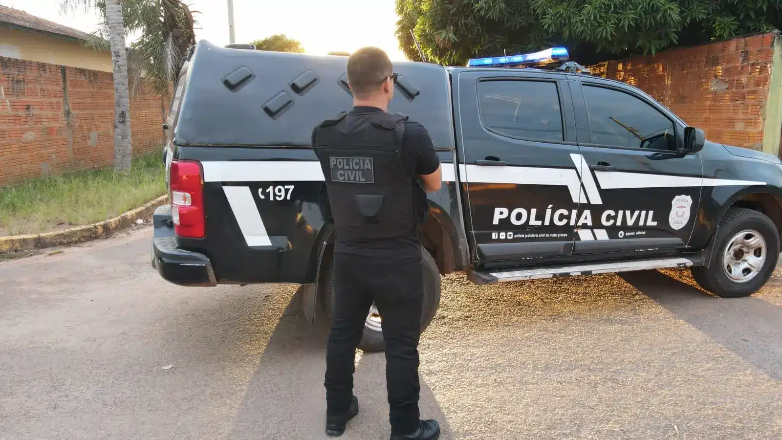 Policial da Polícia Civil do Mato Grosso em frente a viatura, demonstrando a atuação da corporação em ações de segurança pública.