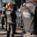 Grupo de policiais penitenciários em treinamento, com uniformes e coletes, durante ação de segurança.