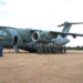 Grupo de militares em uniforme de voo posando ao lado de aeronave KC-390 na pista de base aérea