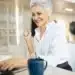 Mulher madura sorrindo enquanto trabalha no notebook, representando nova fase profissional após os 40 anos.
