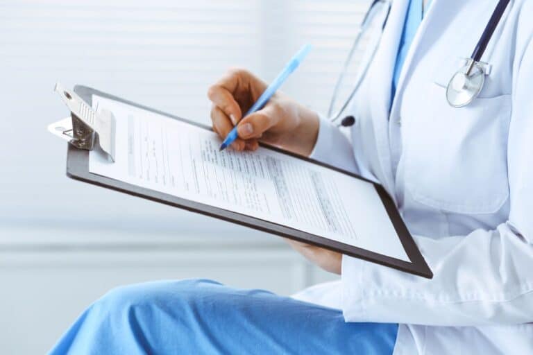Médica preenchendo um formulário médico durante atendimento da perícia médica.