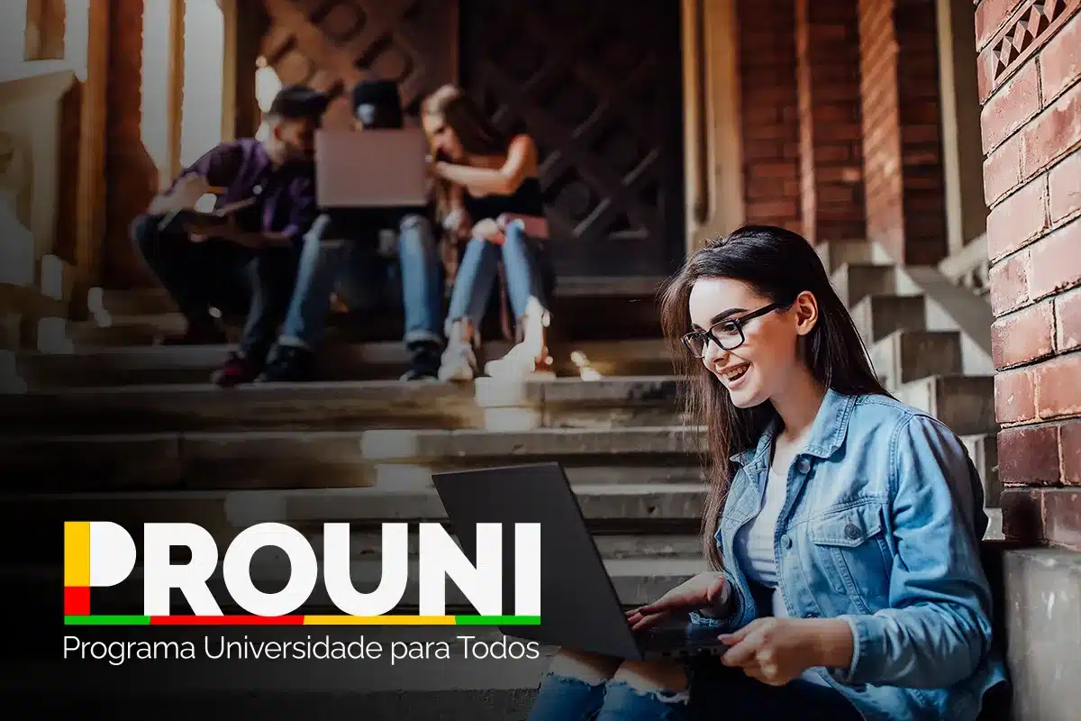 Segunda chamada do Prouni Jovens sentados em escadaria de universidade estudando juntos com notebooks.