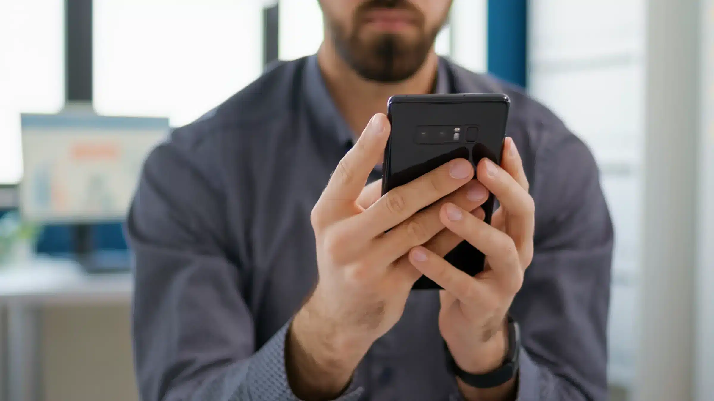 Homem verificando mensagens no celular como exemplo de análise de possíveis tentativas de golpe digital.