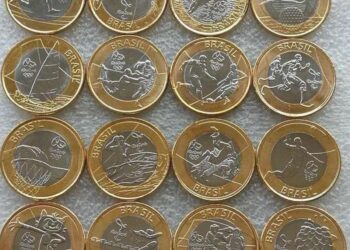 Coleção completa com 16 moedas de 1 Real comemorativas dos Jogos Olímpicos Rio 2016, exibindo diferentes modalidades esportivas e os mascotes Tom e Vinícius sobre um fundo cinza.