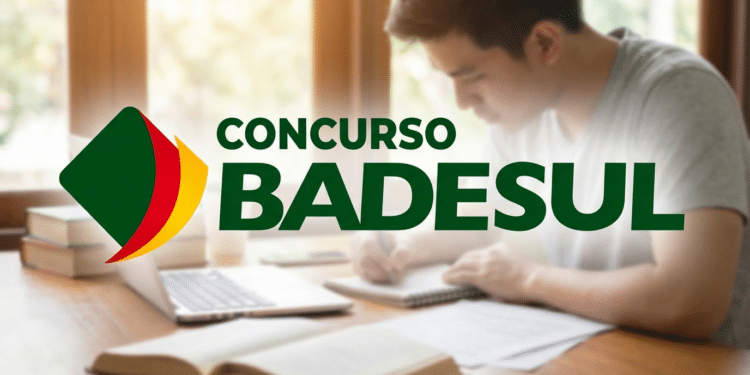 Homem faz anotações em caderno ao lado de livros e notebook com logo do BADESUL