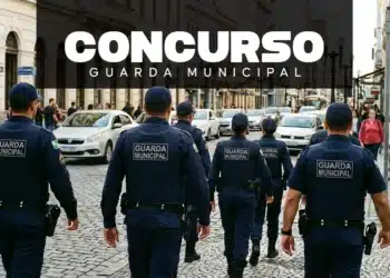 Guardas municipais caminham em grupo por rua movimentada com carros e pedestres