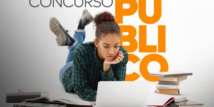 Jovem deitada lendo no notebook, rodeada de livros abertos e empilhados
