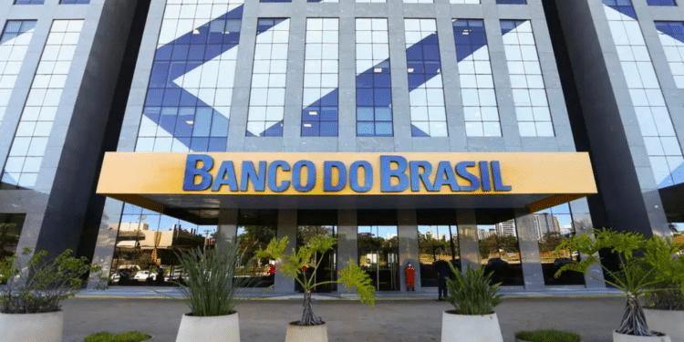 Prédio espelhado do Banco do Brasil com letreiro amarelo e plantas na entrada