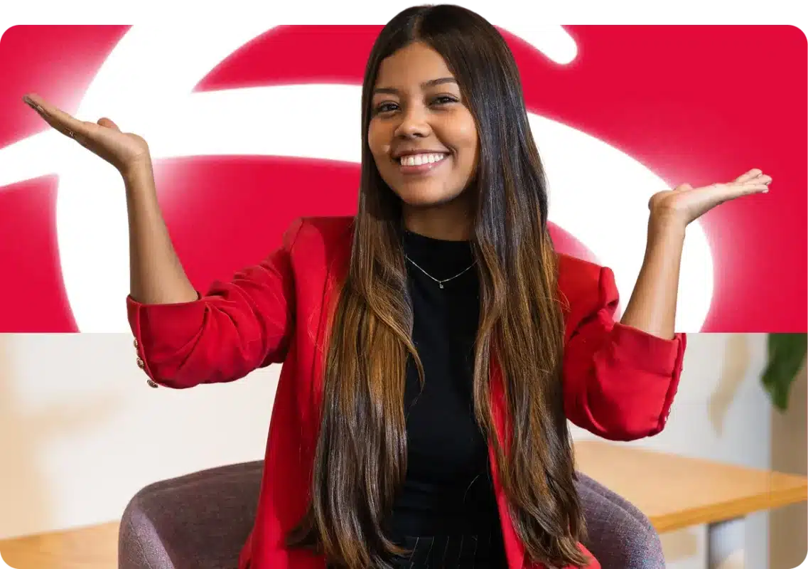 Jovem sorrindo com blazer vermelho na frente da logomarca do Bradesco — vagas de estágio e jovem aprendiz Bradesco 2026