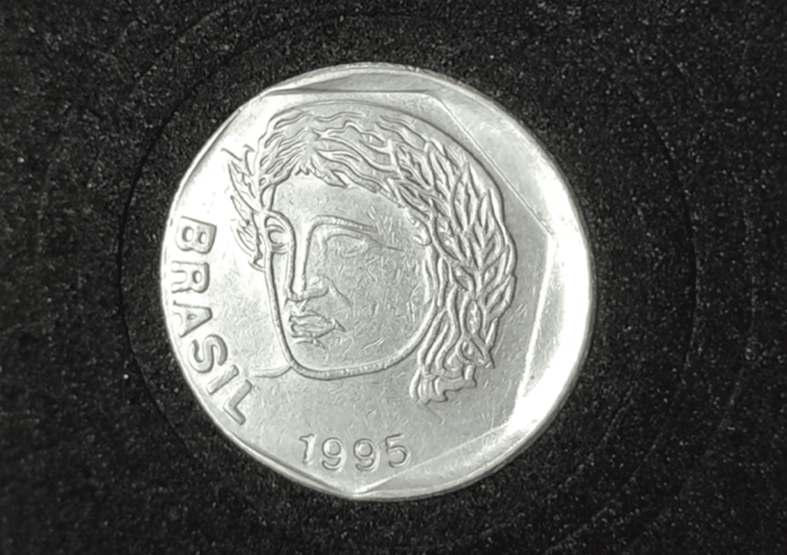 Anverso de moeda de 25 centavos de 1995 com erro de cunhagem "boné", apresentando a efígie da República deslocada e borda esquerda larga.