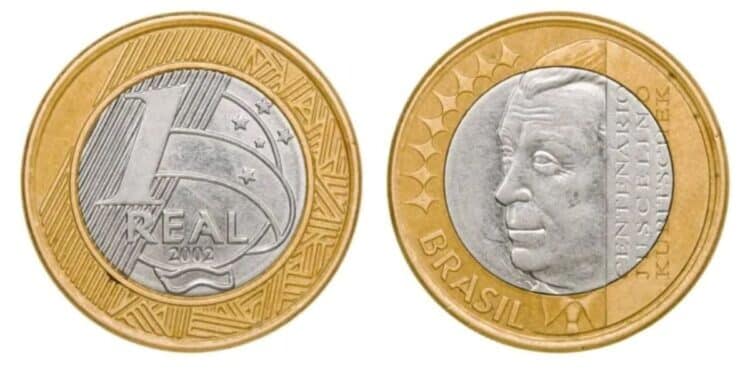 Lado a lado, as duas faces da moeda de 1 real de 2002. À esquerda, o valor de face com a data. À direita, o busto de Juscelino Kubitschek com a inscrição Centenário Juscelino Kubitschek.