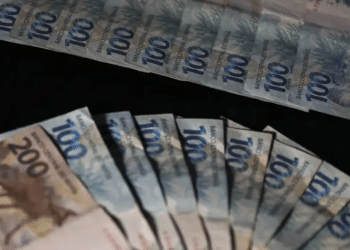 Leque de cédulas de R$ 100 e R$ 200 em fundo escuro — novo salário mínimo de R$ 2.500 beneficiará mais de 10,6 milhões de trabalhadores