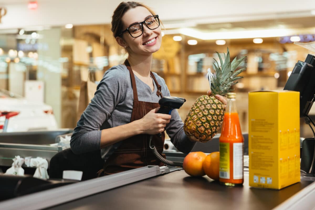 Caixa de supermercado passando produtos pelo leitor de código de barras — profissões com risco de desaparecer até 2035 por causa da automação