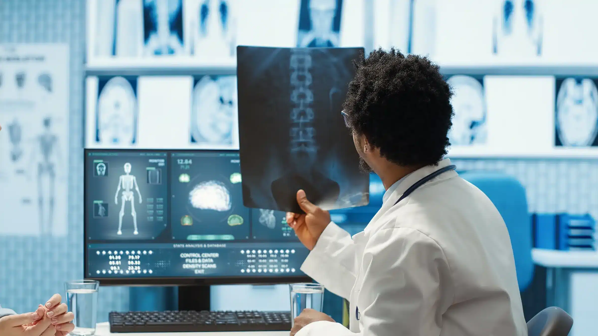 Técnico em radiologia analisando exames de imagem em computador, papel fundamental na saúde.