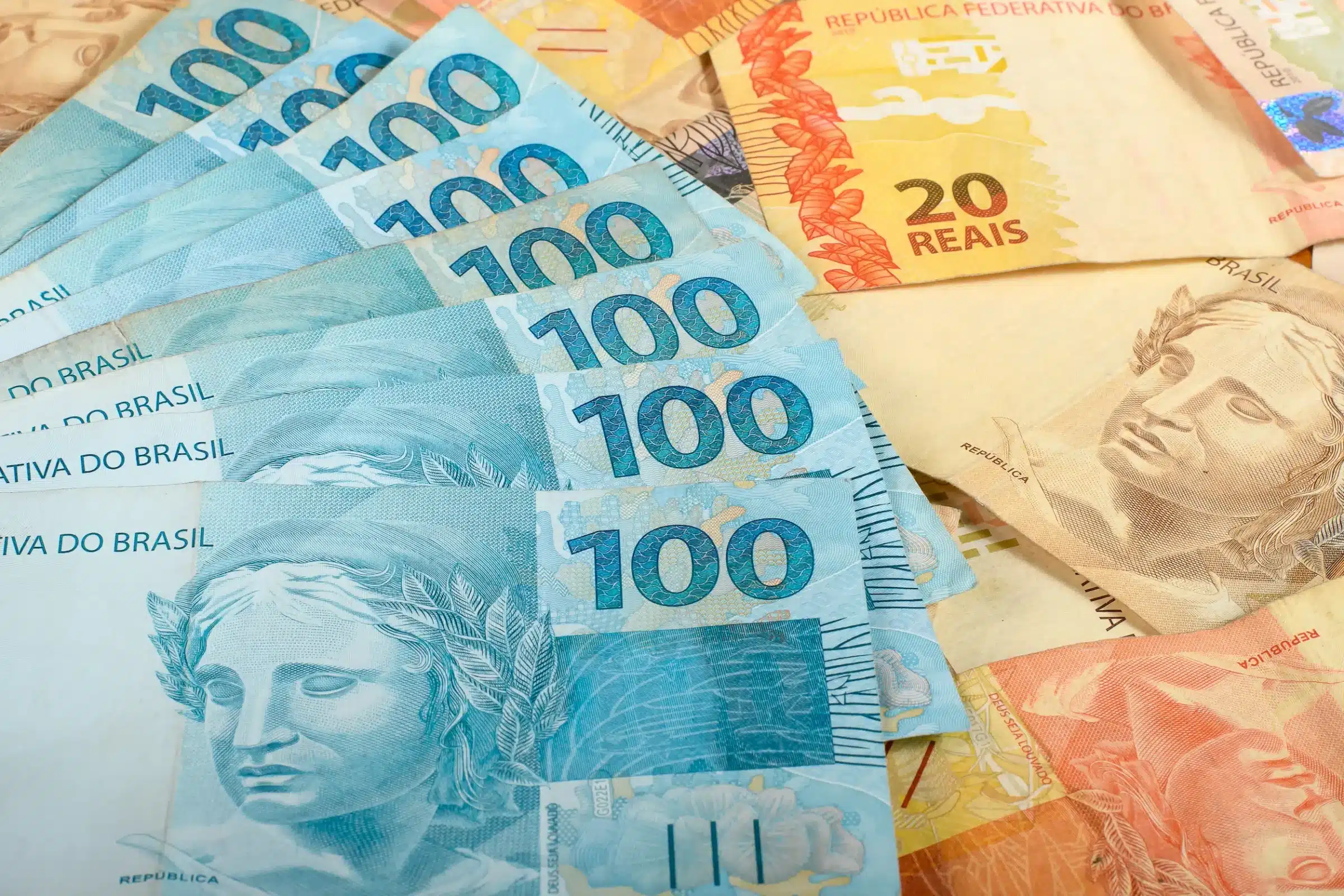 Notas de R$ 100, R$ 50 e R$ 20 ilustrando o valor da primeira parcela do 13º salário para beneficiários do INSS que recebem o piso previdenciário de R$ 1.621.