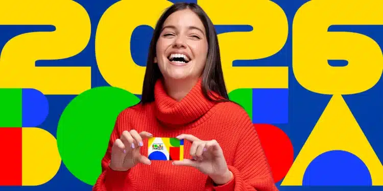 Beneficiária do Bolsa Família segurando cartão do programa enquanto consulta calendário de pagamentos de abril.