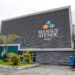 Fachada do prédio da SEMEF Manaus Atende, com estrutura cinza moderna e logomarca colorida, representando a sede da Secretaria Municipal de Finanças de Manaus.
