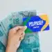 Cartão PIS/PASEP da Caixa sobre notas de R$ 100,00.