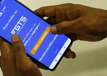 Trabalhador acessando o aplicativo da Caixa para consultar o FGTS, com foco na possível liberação de R$ 17 bilhões para ajudar trabalhadores endividados.
