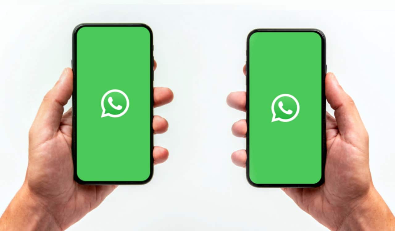 Imagem de dois celulares sendo segurados por mãos, ambos com o logo do WhatsApp na tela, representando o uso do WhatsApp em dois dispositivos.