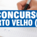 Mão segurando caneta sobre folha de prova com texto Concurso Porto Velho (RO) em faixa azul