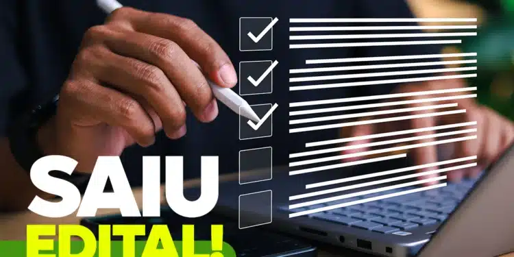 Mão segurando caneta branca em frente a notebook com checklist virtual e texto "Saiu Edital!" em destaque.