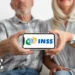 Casal de idosos segurando celular com logo do INSS, ilustrando mudanças nas regras do empréstimo consignado.
