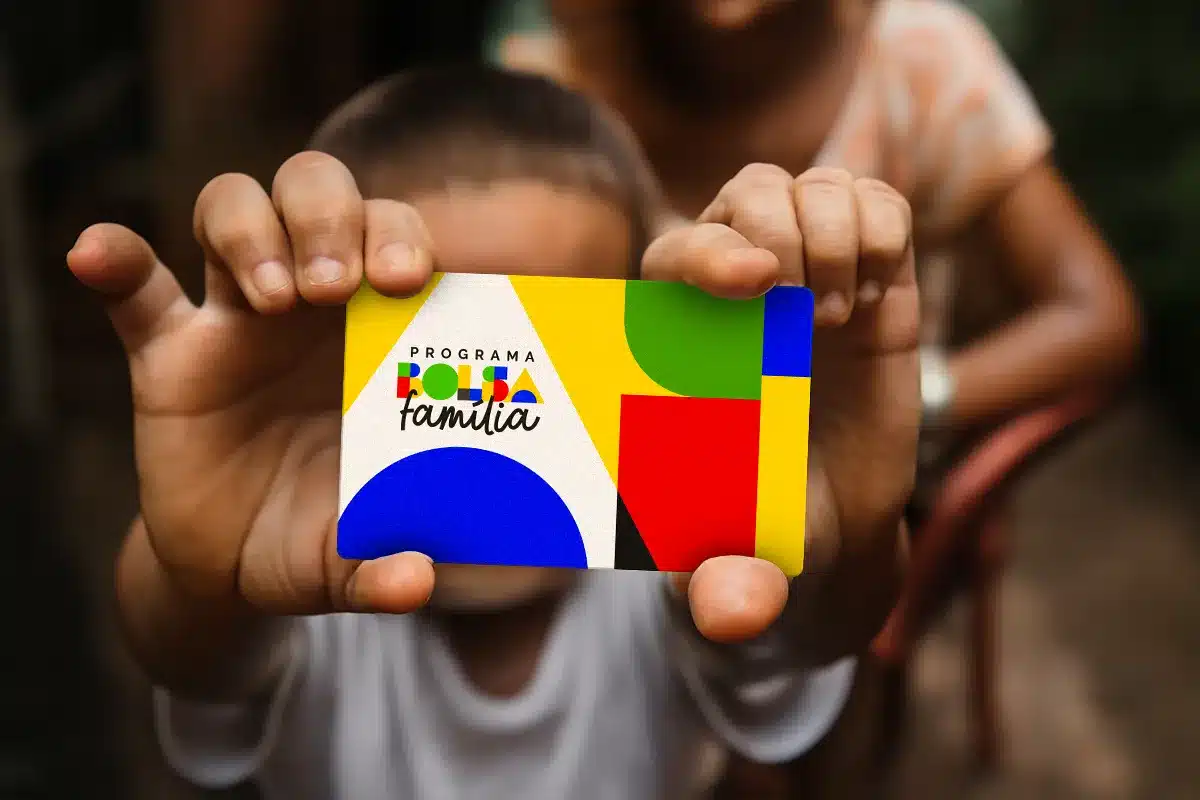 Pessoa segurando cartão do Bolsa Família, simbolizando o monitoramento e verificação de dados.