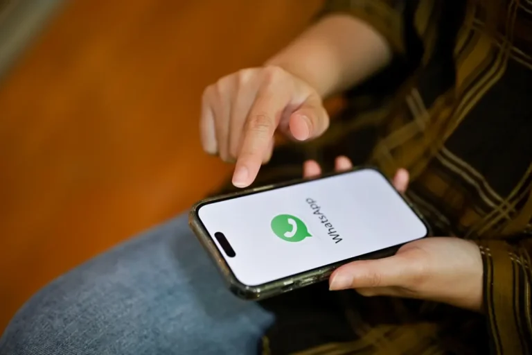 Pessoa utilizando celular com aplicativo WhatsApp aberto enquanto interage com a tela durante possível chamada
