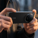 Mãos segurando smartphone Honor Magic9 preto com módulo de câmeras circular e quatro lentes visíveis em ambiente urbano