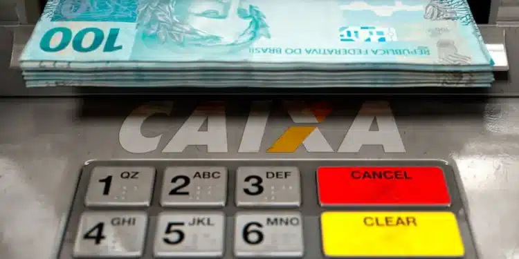 Caixa eletrônico com cédulas de R$ 100 sendo retiradas, relacionada ao saque de R$ 6.220 liberado pela CAIXA para diversos brasileiros.