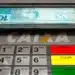 Caixa eletrônico com cédulas de R$ 100 sendo retiradas, relacionada ao saque de R$ 6.220 liberado pela CAIXA para diversos brasileiros.