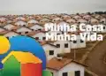 Conjunto de casas populares com telhados cerâmicos, aquecedor solar e logo do programa MCMV