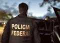 Policial federal com uniforme da Polícia Federal durante anúncio de novas contratações, com foco em segurança pública.