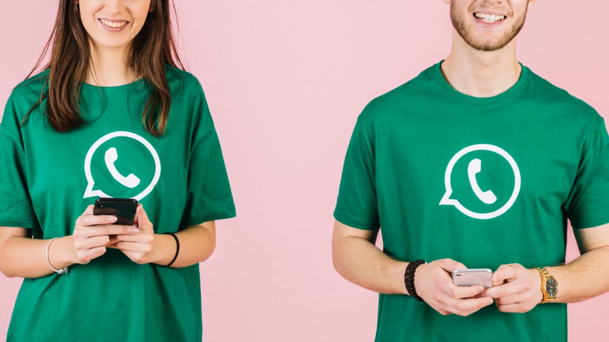 Homem e mulher com camisetas verdes do WhatsApp usando smartphones
