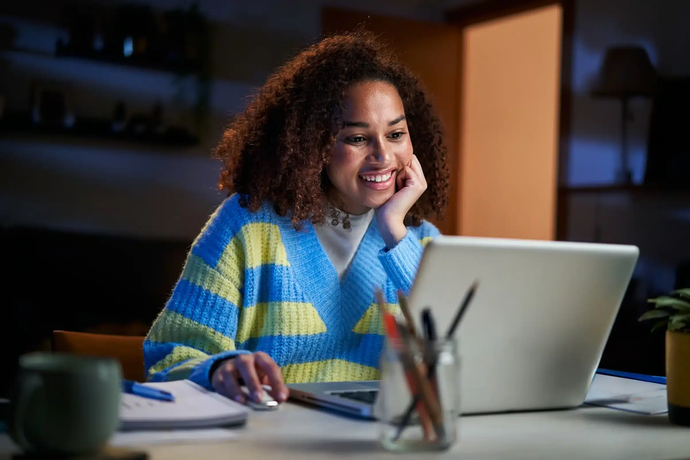 Estudante universitária participando de processo seletivo online em notebook.