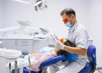 Jovem em consulta odontológica representando o atendimento dentário gratuito em 156 municípios
