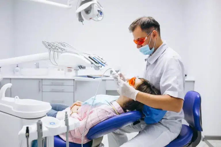 Jovem em consulta odontológica representando o atendimento dentário gratuito em 156 municípios