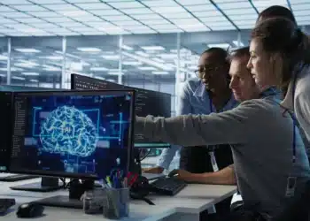 Equipe de profissionais analisando dados de inteligência artificial no ambiente de trabalho, com foco em crescimento de 642% no mercado de treinadores de IA no Brasil.