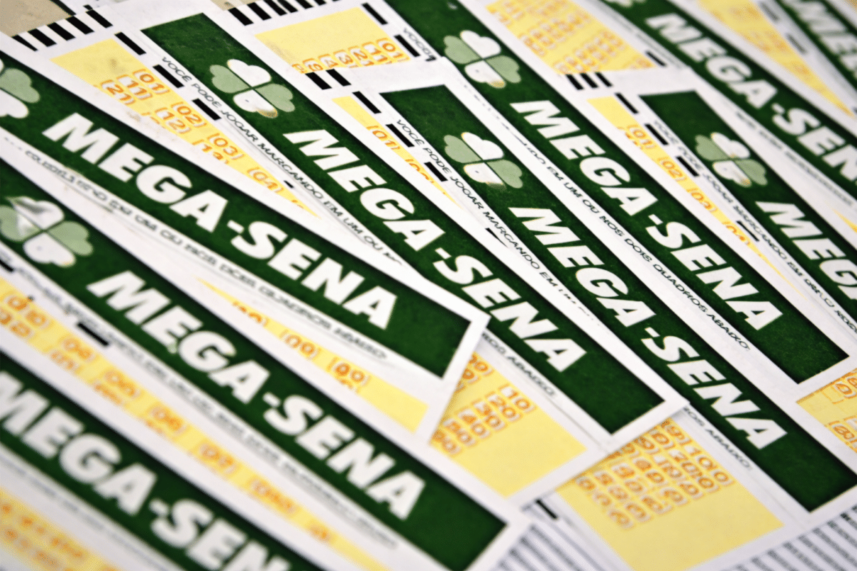 Diversos volantes da Mega-Sena espalhados sobre uma mesa, representando o concurso especial de 30 anos da loteria da Caixa