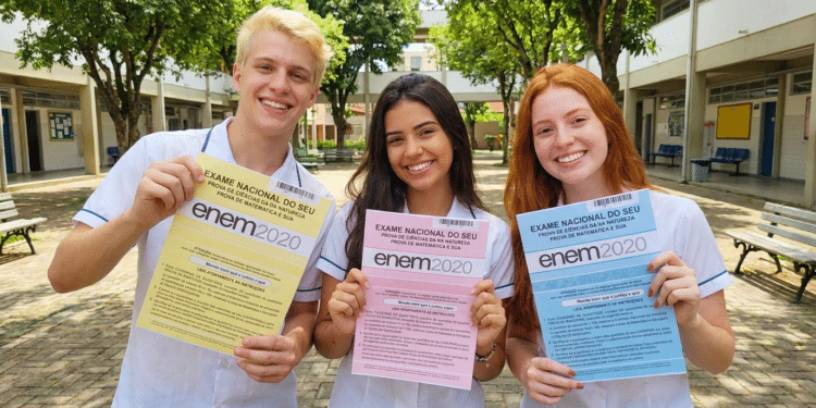 Estudantes exibem provas ENEM 2020 de cores diferentes no pátio escolar.