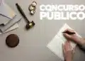 mesa com martelo de juiz e caderno aberto, Nome "CONCURSOS PÚBLICOS" em destaque.